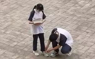 男生蹲下给女同学系鞋带，女生鞠躬表示感谢！网友：这就是青春的样子！