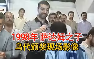 实录1998年萨达姆之子乌代的颁奖现场，随身配枪，领奖者面露难色